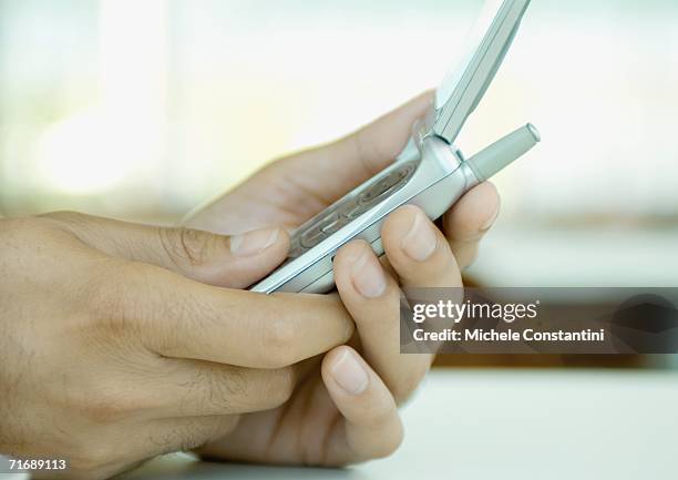 hands holding cell phone - feature phone stockfoto's en -beelden