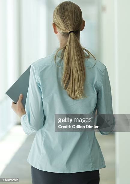 female office worker walking through corridor, rear view - bluse stock-fotos und bilder