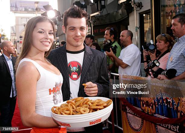 Actor Mike Erwin poses with a Hooters girl as he arrives at the Warner Brothers premiere of "Beerfest" at the Grauman's Chinese Theatre on August 21,...