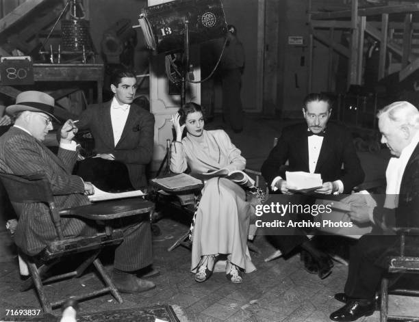 Script conference on the set of the 20th Century Fox film 'Cafe Metropole', 1937. From left to right, director Edward H. Griffith , and actors Tyrone...