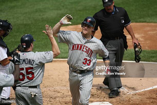 Justin Morneau of the Minnesota Twins celebrates with Mike Redmond after Morneau hit a home run during the game against the Chicago White Sox at U.S....