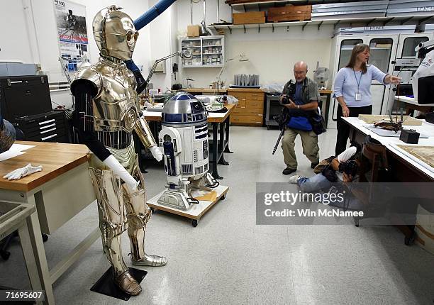 Photographers take pictures of the droids R-2D2 and C-3PO from the movie "Star Wars" in the Objects Lab at the Smithsonian National Museum of...