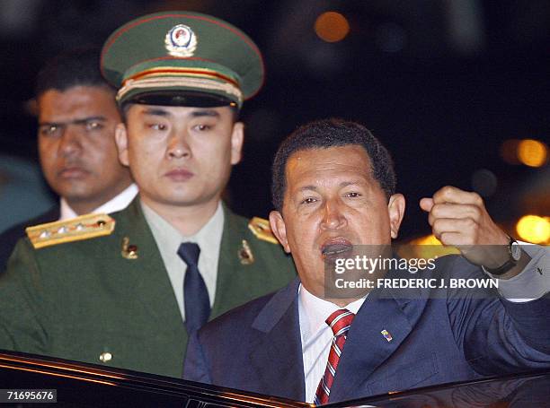 Venezuela President Hugo Chavez , watched by a Chinese military officer , gestures before stepping into a vehicle on arrival at Beijing airport,...