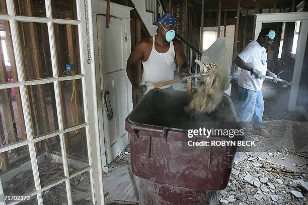 New Orleans, UNITED STATES: Don Woods and his brother-in-law Frederick Smith remove debris as they gut Woods' home in the Lower Ninth Ward of New...