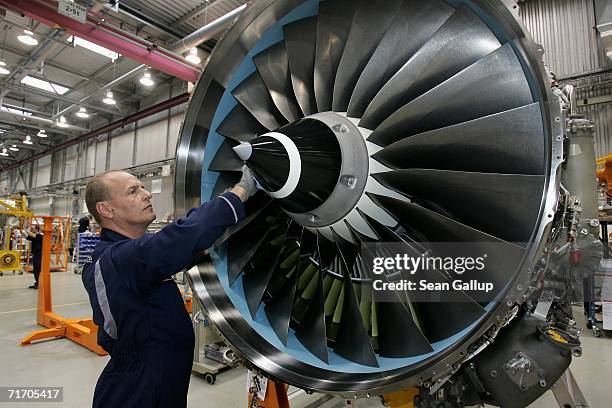 Worker scrubs the turbine of an aircraft jet engine August 23, 2006 at the Rolls-Royce aircraft engine factory in Berlin, Germany. The factory, a...