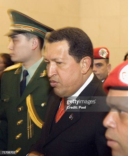 Venezuelan President Hugo Chavez is flanked by Chinese and Venezuelan military officers as he leaves a signing ceremony with Chinese President Hu...