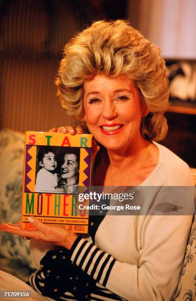 Author and mother of actress and singer Cher, Georgia Holt, holds a copy of her book "Star Mothers" during a 1988 Los Angeles, California, photo...