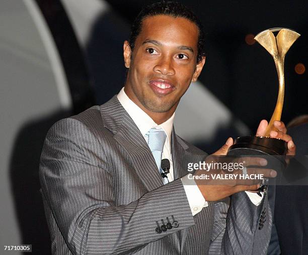 Barcelona's forward Brazilian Ronaldinho poses with trophy of the best player of the year during the draw for the group stages of the 2006/2007...