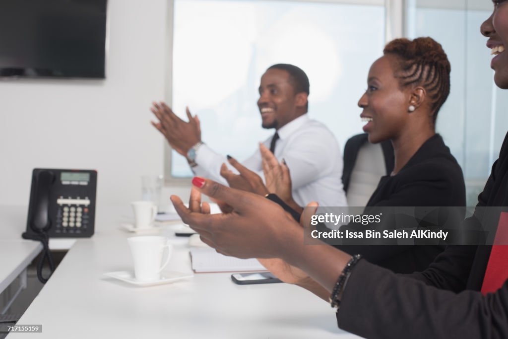 African business people clapping in conference room