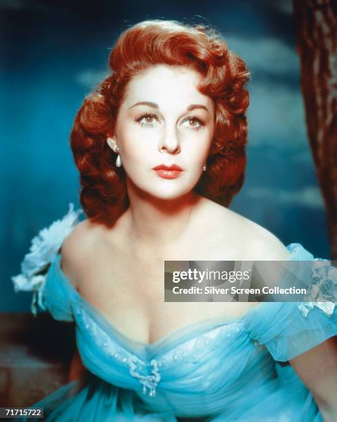 American actress Susan Hayward contrasts her red hair with a blue dress, circa 1950.