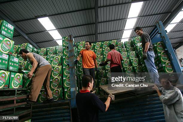 Workers load boxes of Tsingtao beer onto a truck at the Tsingtao beer factory on August 25, 2006 in Qingdao, Shandong Province of China. Tsingtao...
