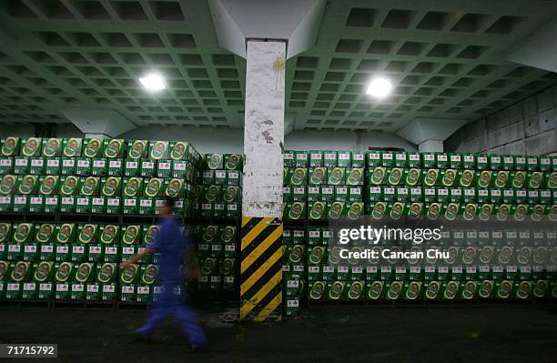 Worker walks in the storehouse of the Tsingtao beer factory on August 25, 2006 in Qingdao, Shandong Province of China. Tsingtao Beer Group, China's...