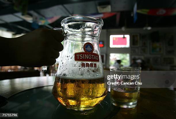 Visitors degust Tsingtao beer at a bar in the Tsingtao beer factory on August 25, 2006 in Qingdao, Shandong Province of China. Tsingtao Beer Group,...