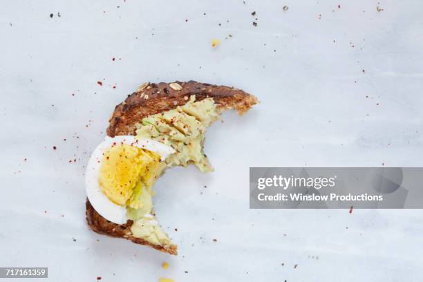 missing bite of toasted bread with avocado and hard boiled egg - missing bite stock pictures, royalty-free photos & images