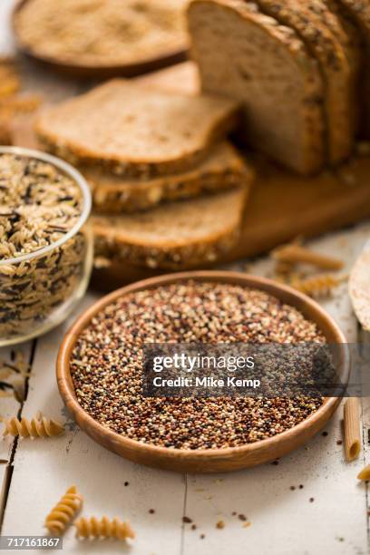 quinoa in bowl and sliced brown bread in background - gluten free bread stock pictures, royalty-free photos & images