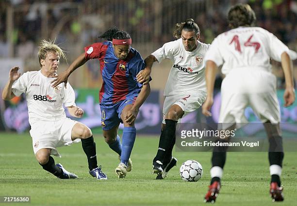 Christian Poulsen of Sevilla tussels for the ball with Ronaldinho of Barcelona, Javi Navarro and Julien Escude of Sevilla during the UEFA Super Cup...