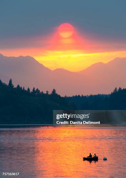 couple looking at dramatic sunset, fletcher bay, olympics and kitsap peninsula, bainbridge island, washington state, usa - bainbridge island 個照片及圖片檔