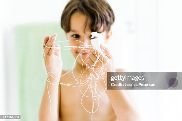 boy (6-7) watching dental floss - zahnseide stock-fotos und bilder