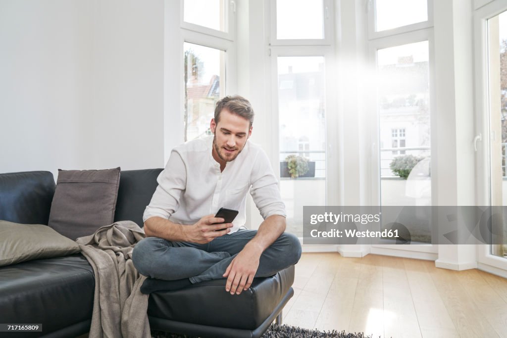 Man sitting on couch looking at cell phone