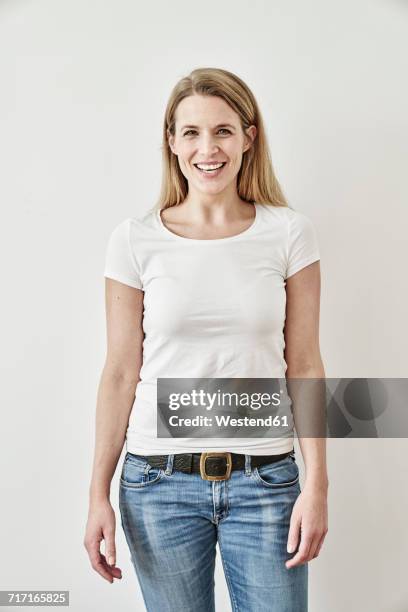 portrait of smiling woman - woman wearing white jeans stock-fotos und bilder