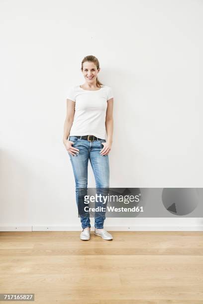 portrait of smiling woman - tshirt jeans stockfoto's en -beelden