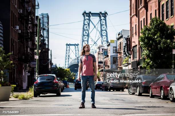 usa, new york city, man standing on the street looking around in williamsburg, brooklyn - williamsburg brooklyn stockfoto's en -beelden