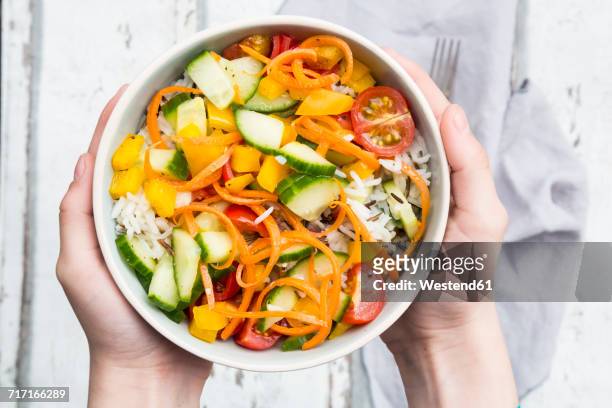 hands holding bowl of rice salad with mixed vegetables - wilde rijst stockfoto's en -beelden