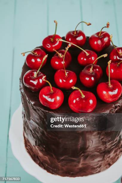 cherries on cake with chocolate icing - cherry on top stock-fotos und bilder