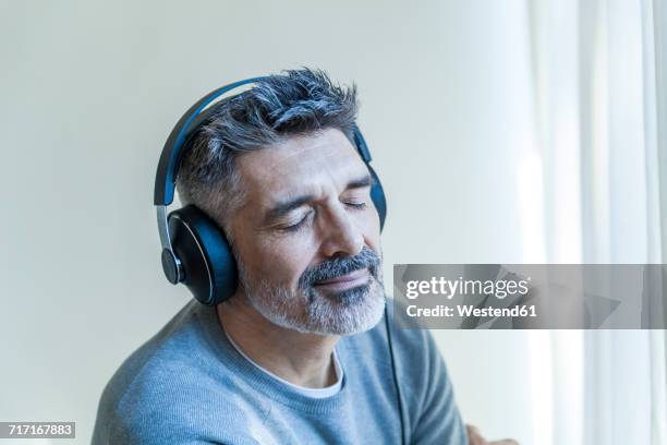 mature man with closed eyes wearing headphones - man smiling eyes closed stock pictures, royalty-free photos & images