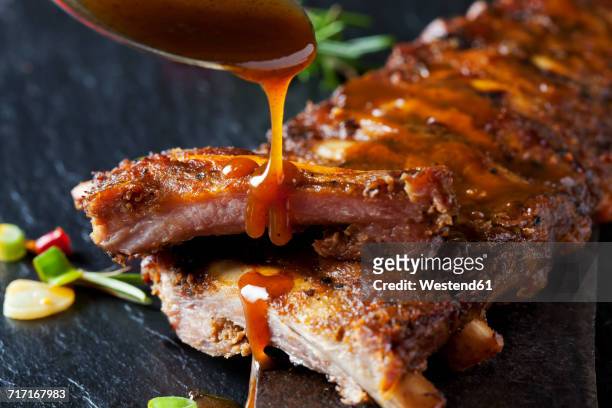 barbecue sauce dripping on marinated and grilled spare ribs - salsa barbecue foto e immagini stock