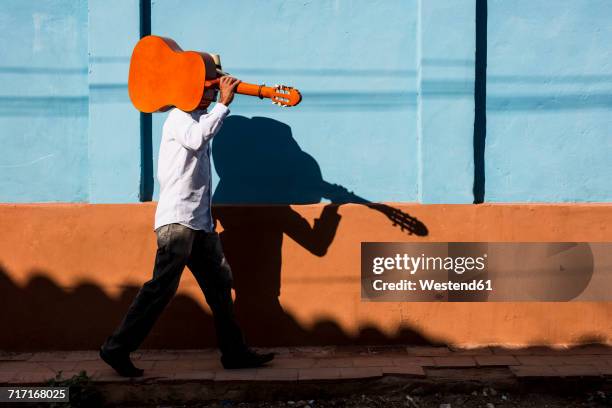 cuba, man with guitar walking on the street - trinidad kuba bildbanksfoton och bilder