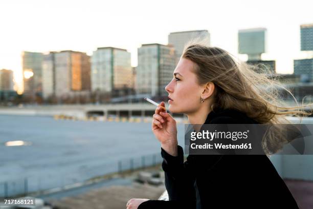 spain, barcelona, pensive young woman smoking cigarette - cigarette stock-fotos und bilder