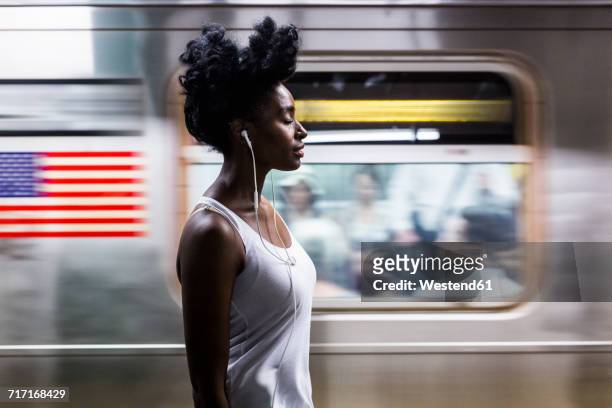 usa, new york city, manhattan, woman with earphones on subway station platform - tunnelbanetåg bildbanksfoton och bilder