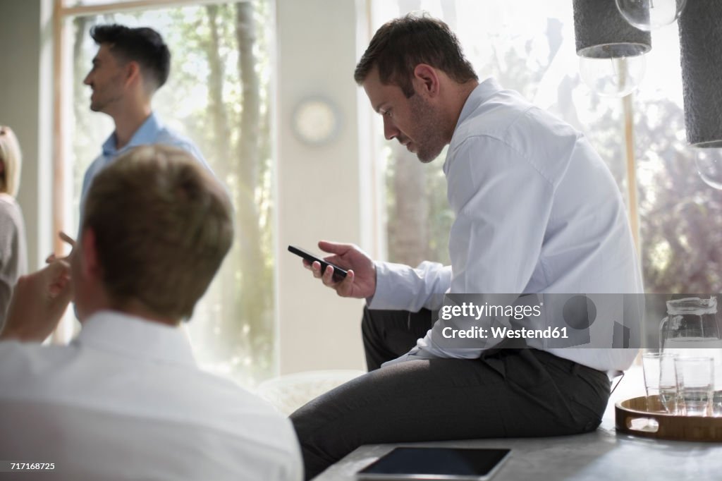 Businessman using smart phone in a meeting