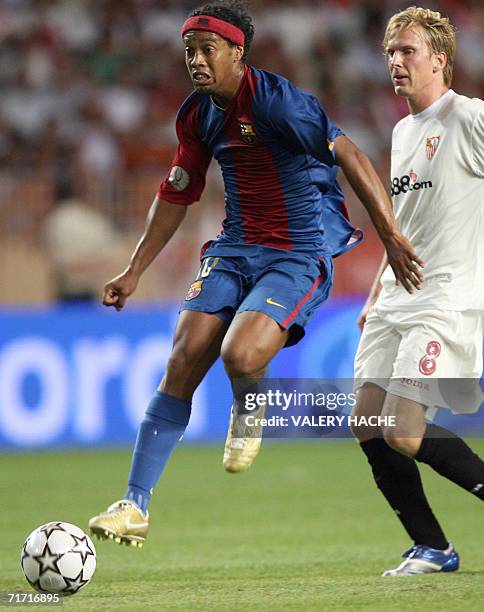 Barcelona's forward Brazilian Ronaldinho vies with Sevilla's midfielder Christian Poulsen during the European Super Cup football match Barcelona vs....