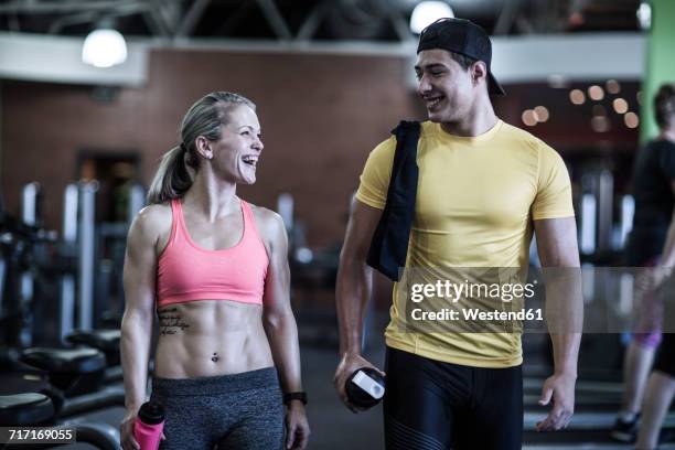 happy young man and woman talking in gym - gym fashion stock pictures, royalty-free photos & images