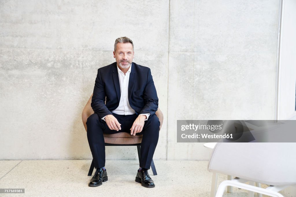 Portrait of smiling businesssman sitting in armchair