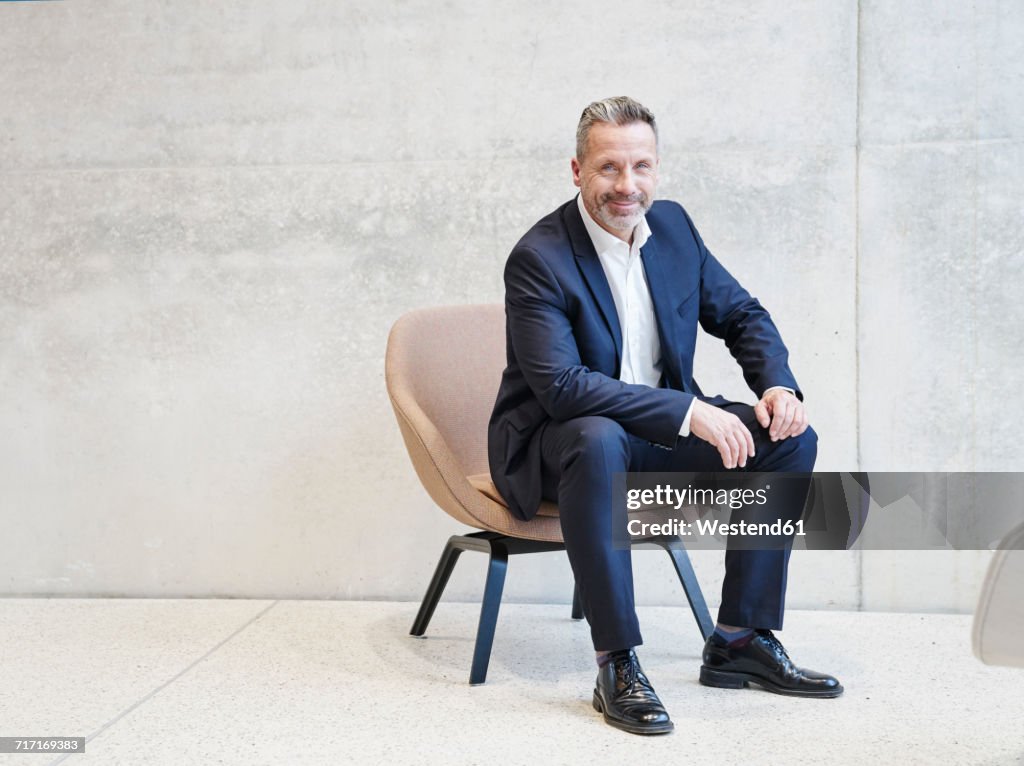 Portrait of smiling businesssman sitting in armchair