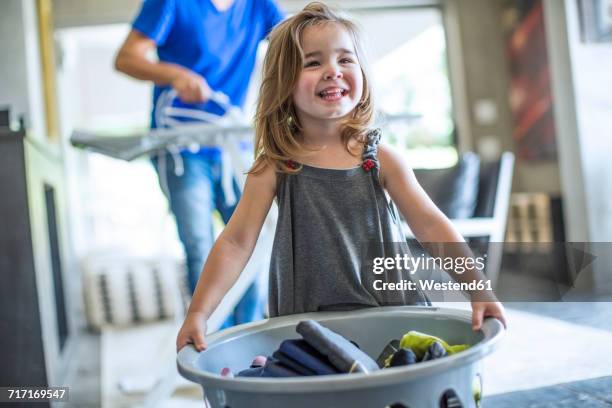 happy baby girl holding laundry basket - laundry basket fotografías e imágenes de stock