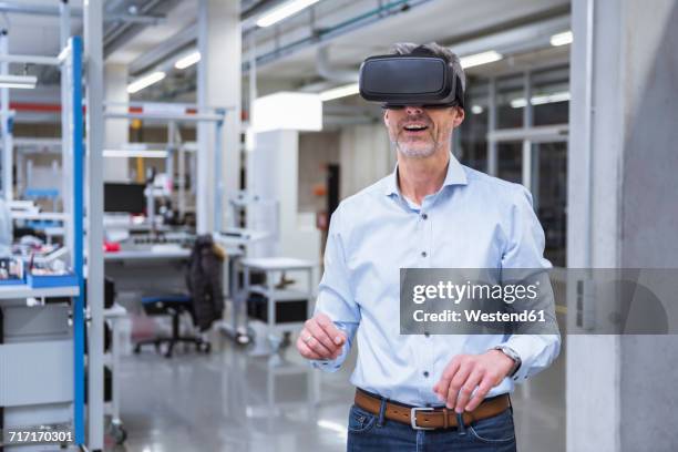 mnagers standing in company, using vr goggles - vr goggles business stockfoto's en -beelden