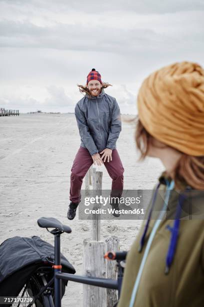 germany, schleswig-holstein, st peter-ording, playful couple on the beach - north frisia stock pictures, royalty-free photos & images