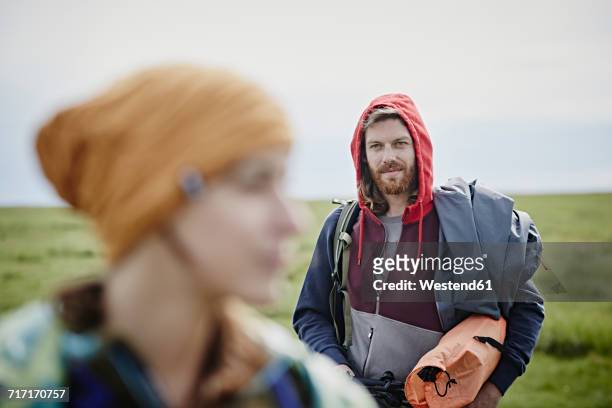 smiling man with woman in foreground on a trip - hood clothing stock pictures, royalty-free photos & images