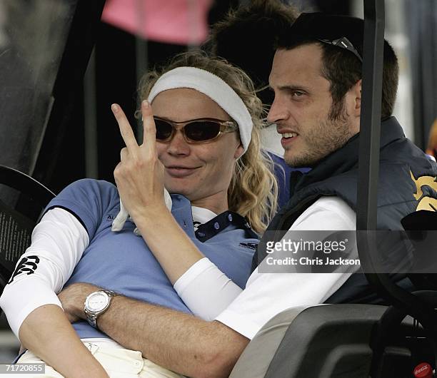 Jodie Kidd sits on her husband Aiden Butler's lap in a golf cart on the first day of the Northern Rock All Star Cup at the Celtic Manor Resort on...
