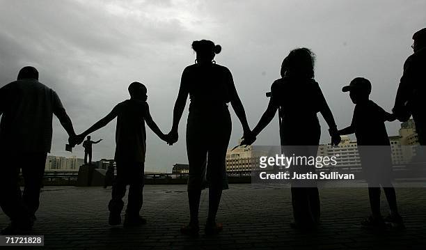 People hold hands as they circle the Louisiana Superdome August 26, 2006 in New Orleans, Louisiana. People held hands and attempted to make a human...