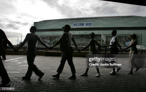 People hold hands as they circle the Louisiana Superdome August 26, 2006 in New Orleans, Louisiana. People held hands and attempted to make a human...