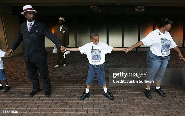 People hold hands as the create a human chain to circle the Louisiana Superdome August 26, 2006 in New Orleans, Louisiana. People held hands and...