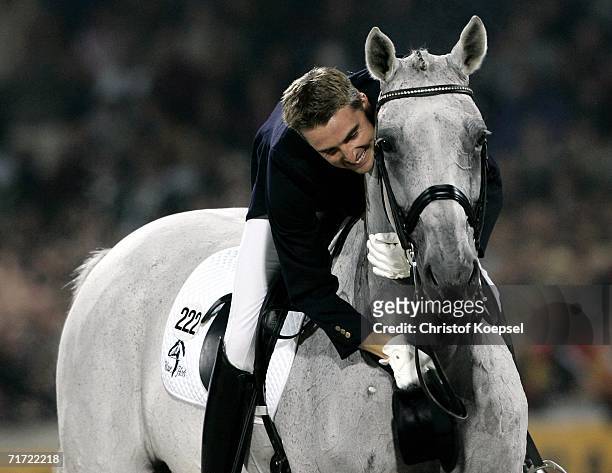 Andreas Helgstrand of Denmark rides on Blue Hors Matinee and embraces his horse after a good presentation during the Dressage Grand Prix Freestyle at...