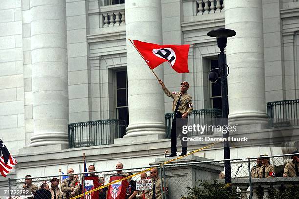 Member of the Minneapolis based National Socialist Movement waves a Nazi flag during a rally at Madison's Capital Square August 26, 2006 in Madison,...