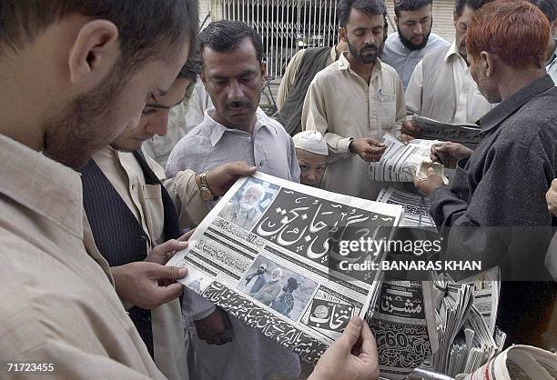 Pakistani men read newspapers with the news of the death of tribal rebel chieftain Nawab Akbar Bugti on the front pages at a roadside stall in...