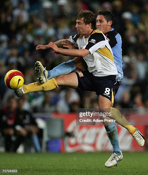 Jamie McMaster of the Mariners is challenged by Mark Milligan of Sydney FC during the round one A-League match between Sydney FC and the Central...